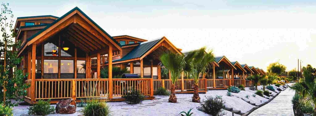 Cozy mountain lodge at Pirate Cove Resort nestled amidst snowy peaks, offering a warm retreat for winter travelers.