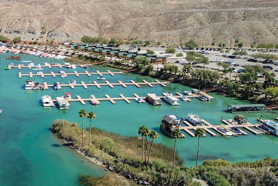 Tranquil marina at Pirate Cove Resort with a fleet of boats moored in calm blue waters.