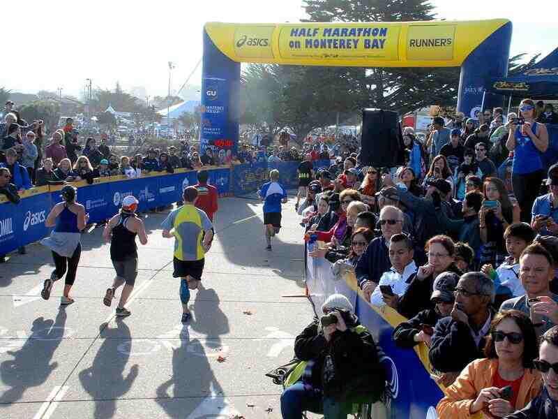 Runners gather at the starting line of the Monterey Bay Half Marathon, buzzing with excitement and anticipation.
