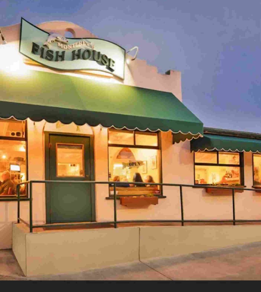 Entrance of Monterey's Fish House with its iconic sign and welcoming facade at dusk.