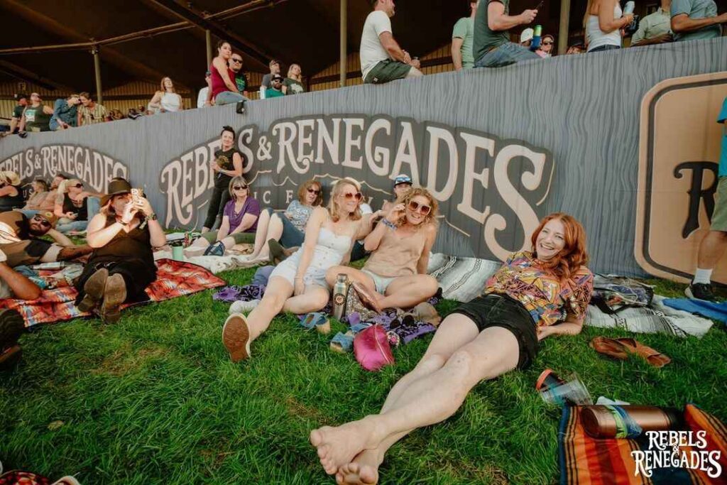 A lively crowd enjoying the Rebels and Renegades Music Festival outdoors.