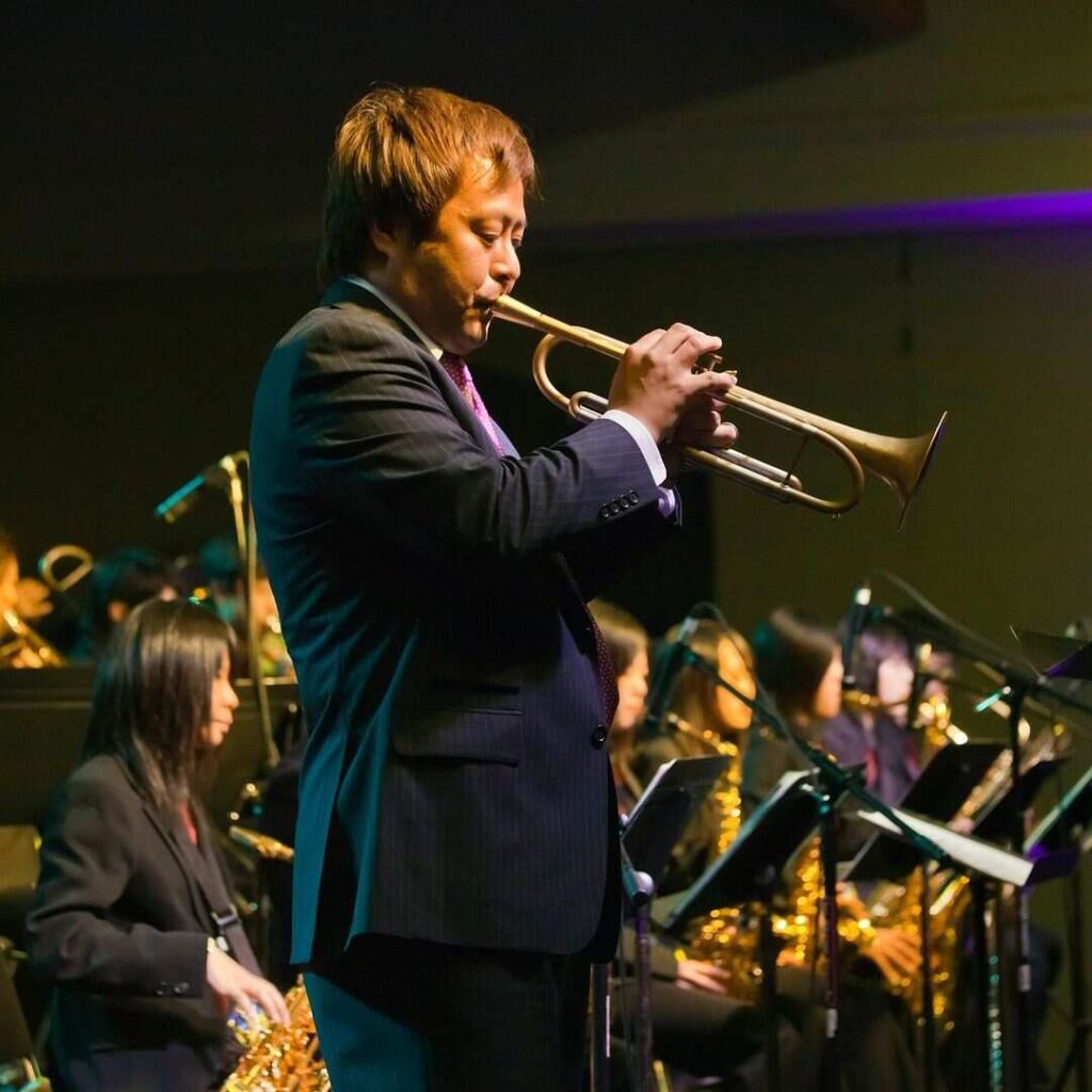 Trumpet player performing live on stage at a jazz event.