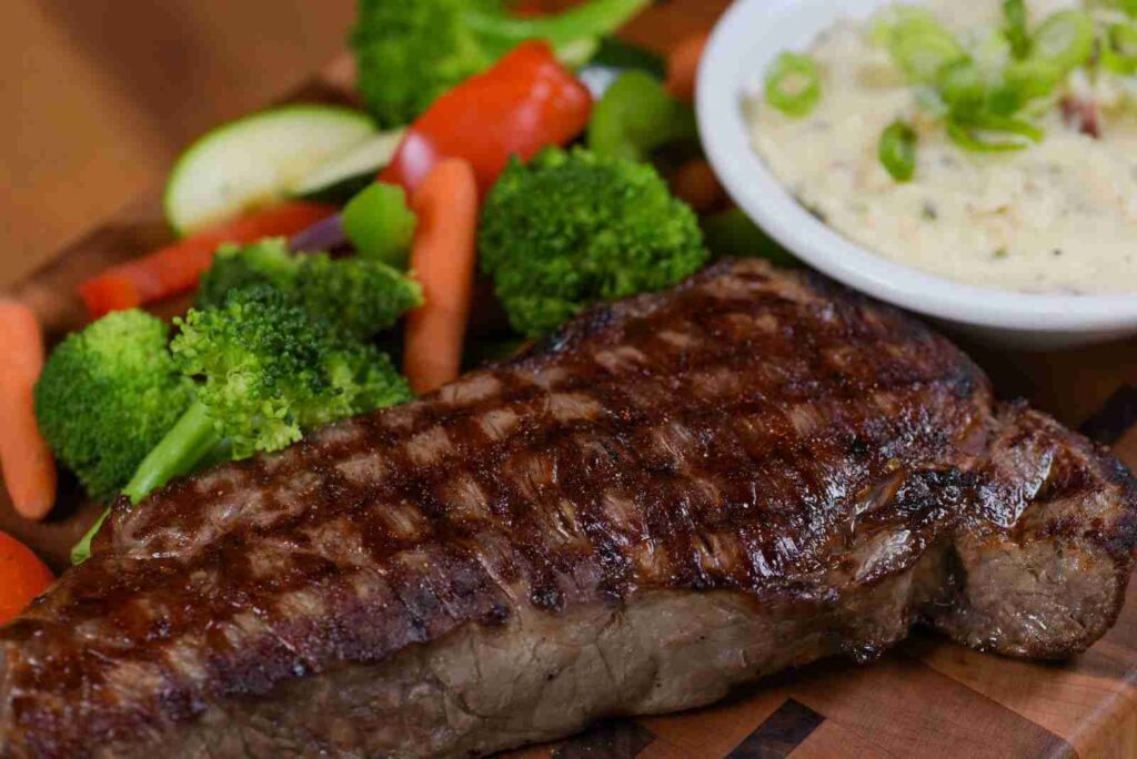 Grilled steak topped with herb butter at Crazy Horse Restaurant, showcasing the restaurant's commitment to mouthwatering, high-quality dishes.