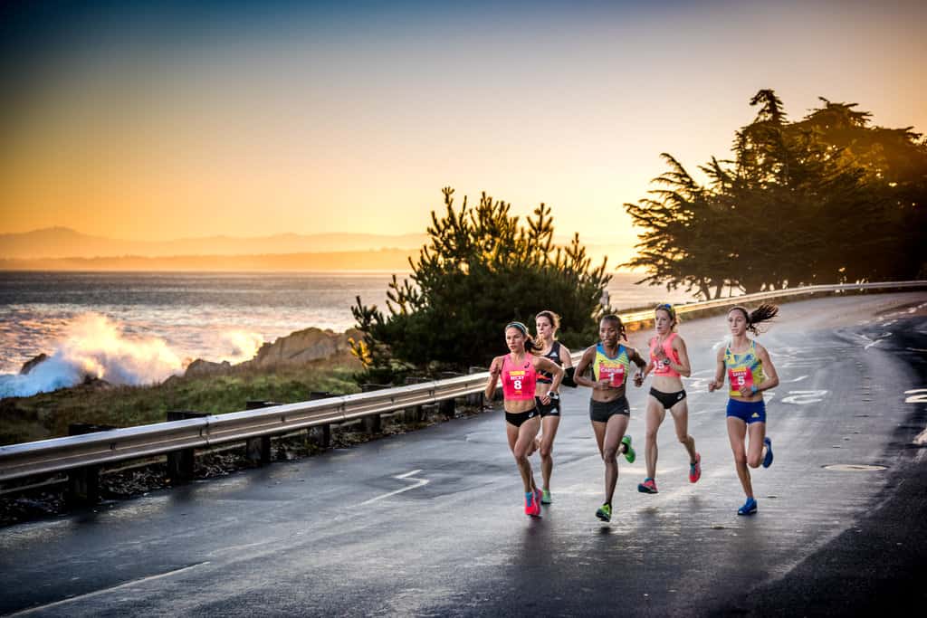 Elite runners race against a stunning sunset backdrop in the Monterey Bay Half Marathon.