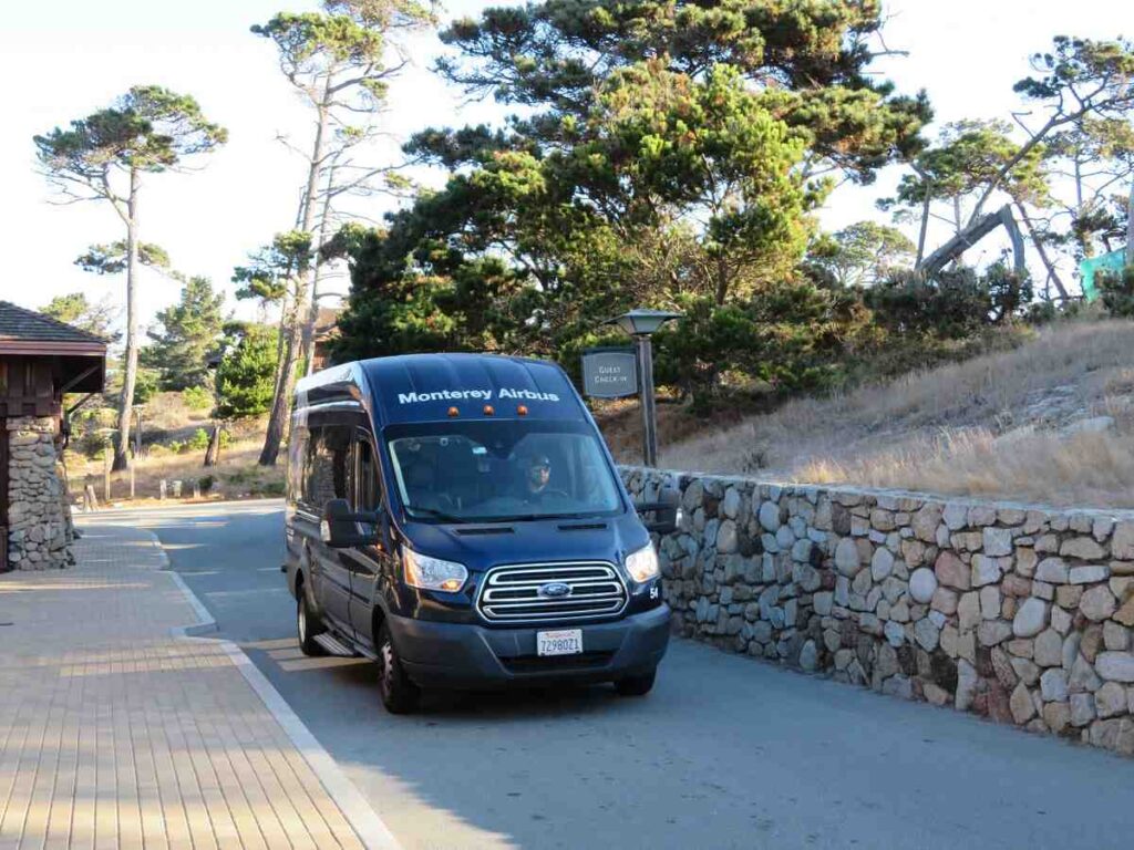 A sleek Monterey Airbus vehicle parked amidst the scenic beauty of Asilomar.