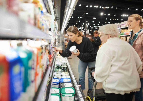 Shot of a senior woman shopping with her daughters at a grocery store